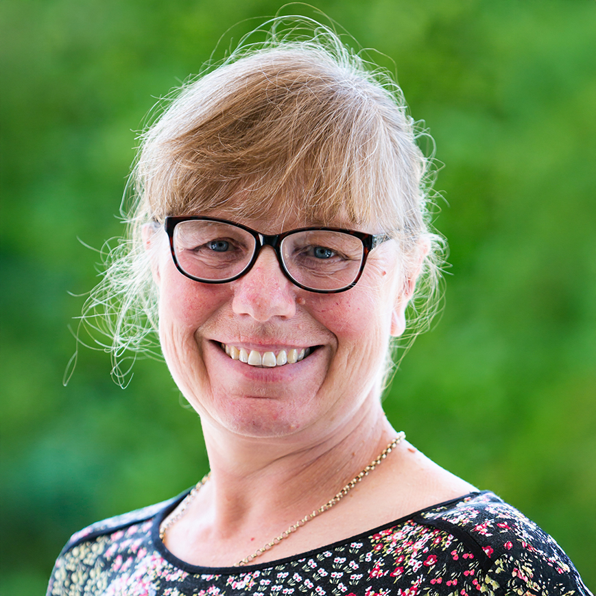 Dawn Green, Finance Director, smiling outdoors against a green background